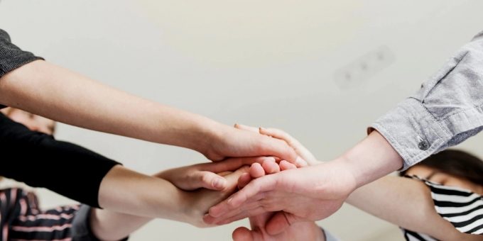 Many hands are overlapped together.