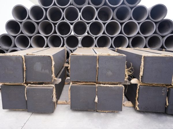 Many graphite blocks and crucibles are placed in the factory yard.