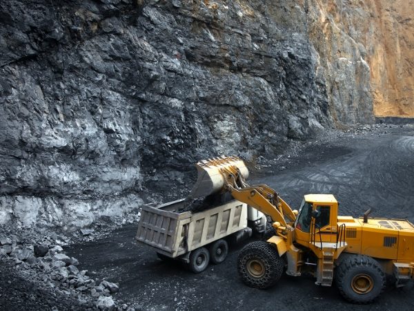 The earthmover is pouring graphite blocks into the truck.