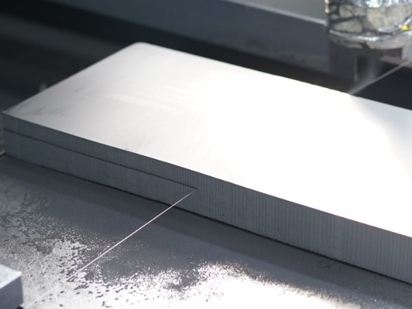 The machine is cutting the graphite plate into desired size.