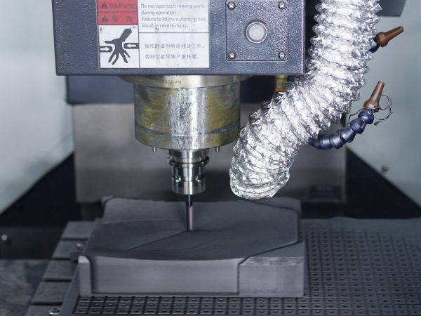 The machine is cutting the graphite block into desired shapes.